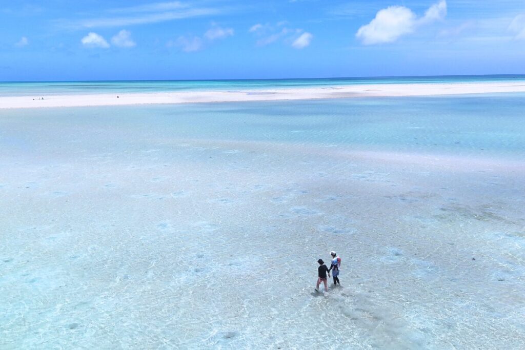上空からユニの浜と周辺の海を撮影浅い海をふたりでさんぽ