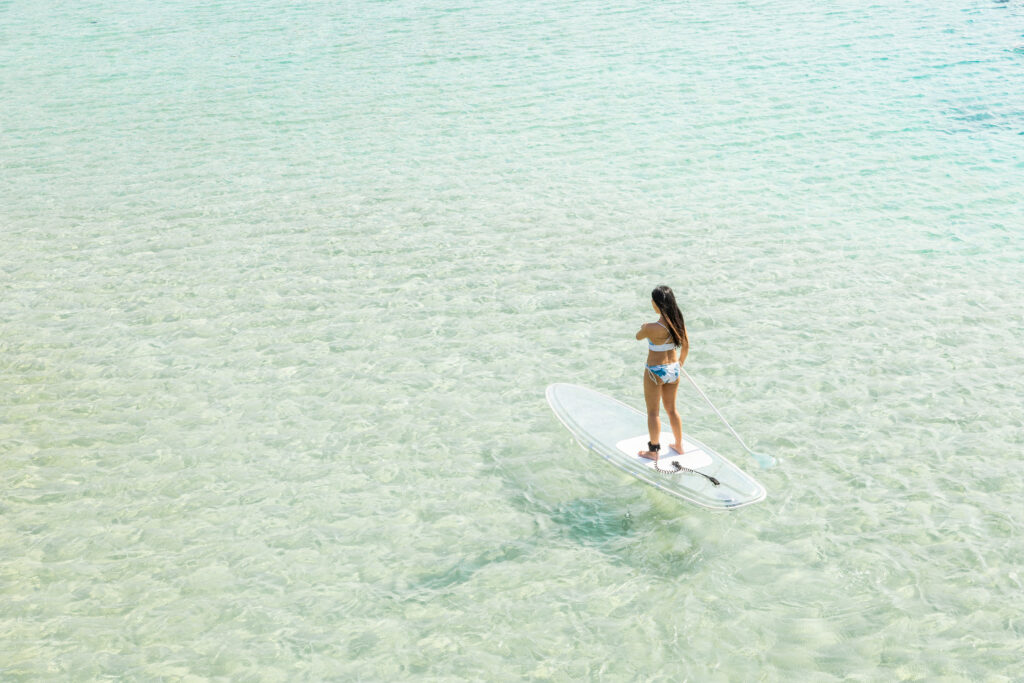 宮古島のクリスタルクリアな海でクリアサップを楽しむ女性