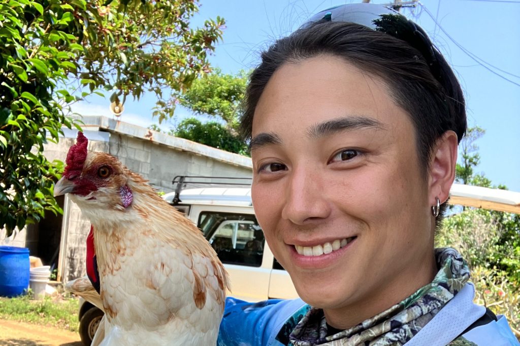 ニワトリとツーショットをとる男性