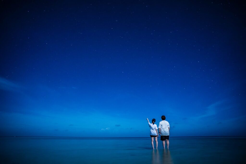 宮古島の海に浮いて星空を眺める女性
