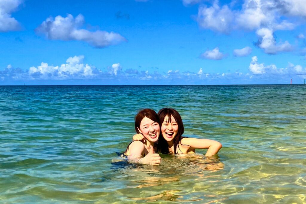 浅瀬ではしゃぐ水着姿の女性ふたり