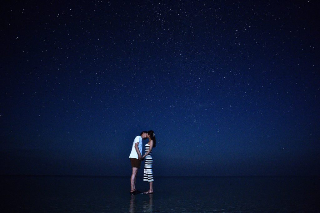 海の上に立ってキスする恋人