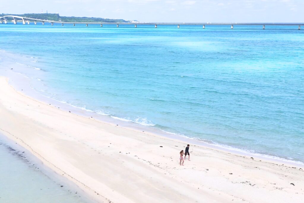 ユニの浜を歩くカップル、ドローン、うみさんぽ