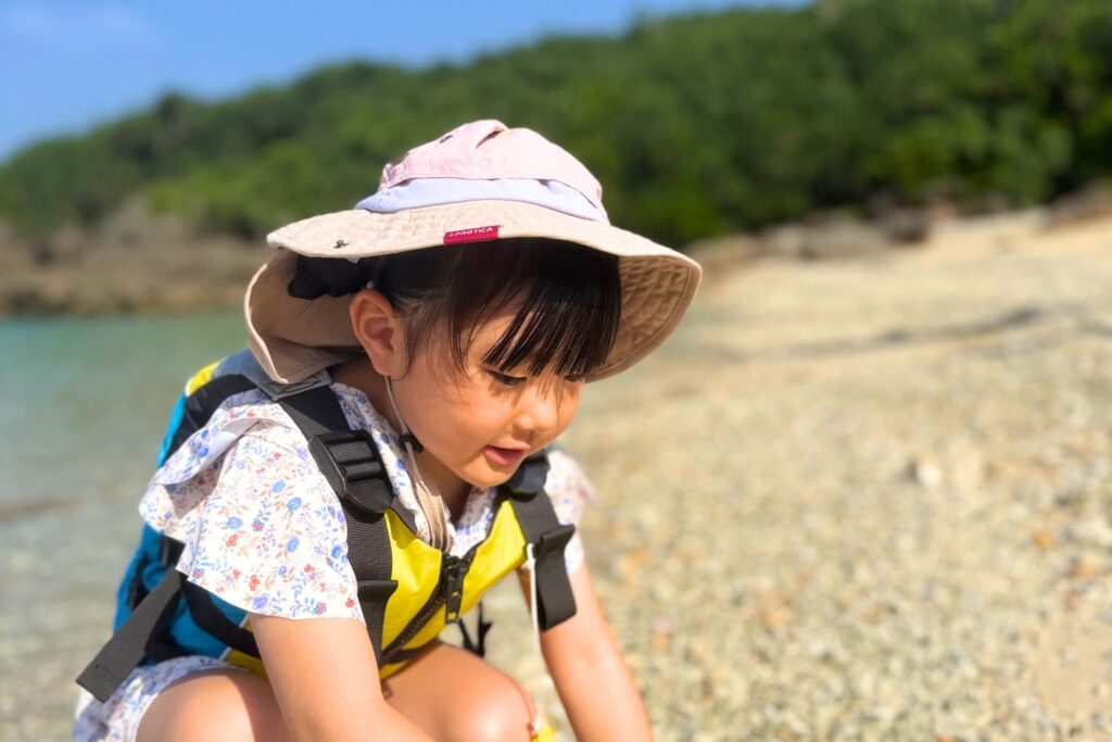 ビーチでやどかりを探す女の子