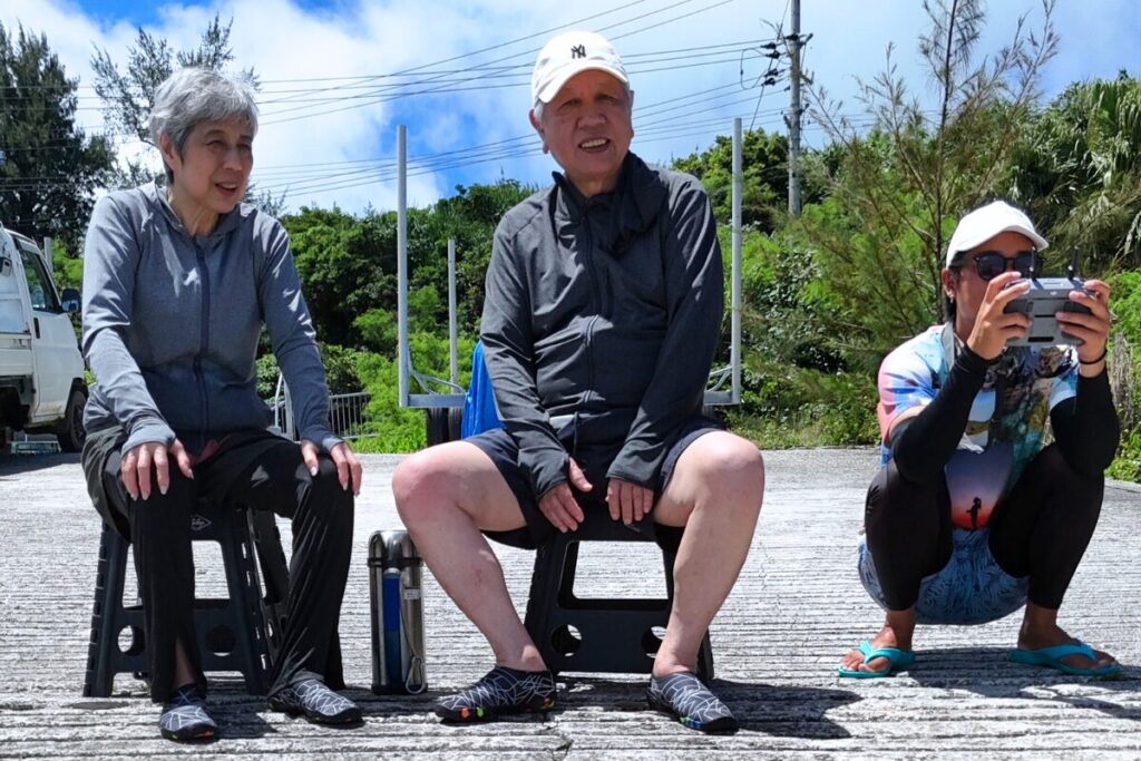 漁港にて椅子に座って休憩。ドローンを飛ばす瞬間に興味津々
