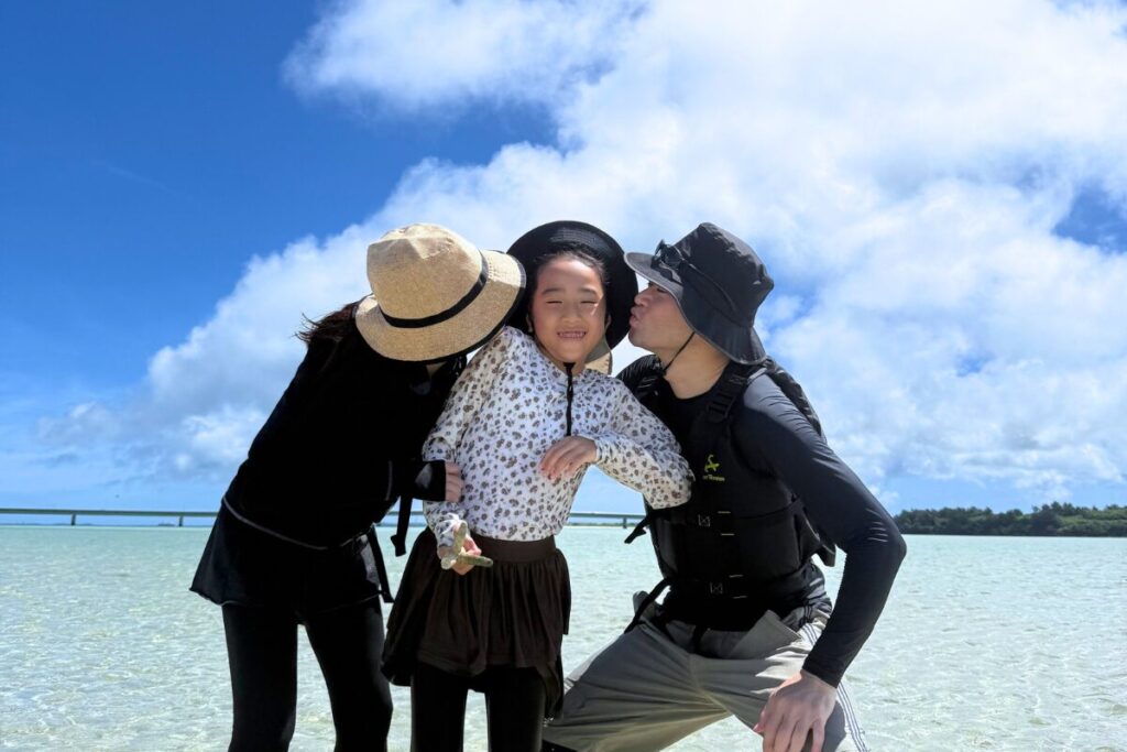 ユニの浜にて娘にキスをするお父さんとお母さん