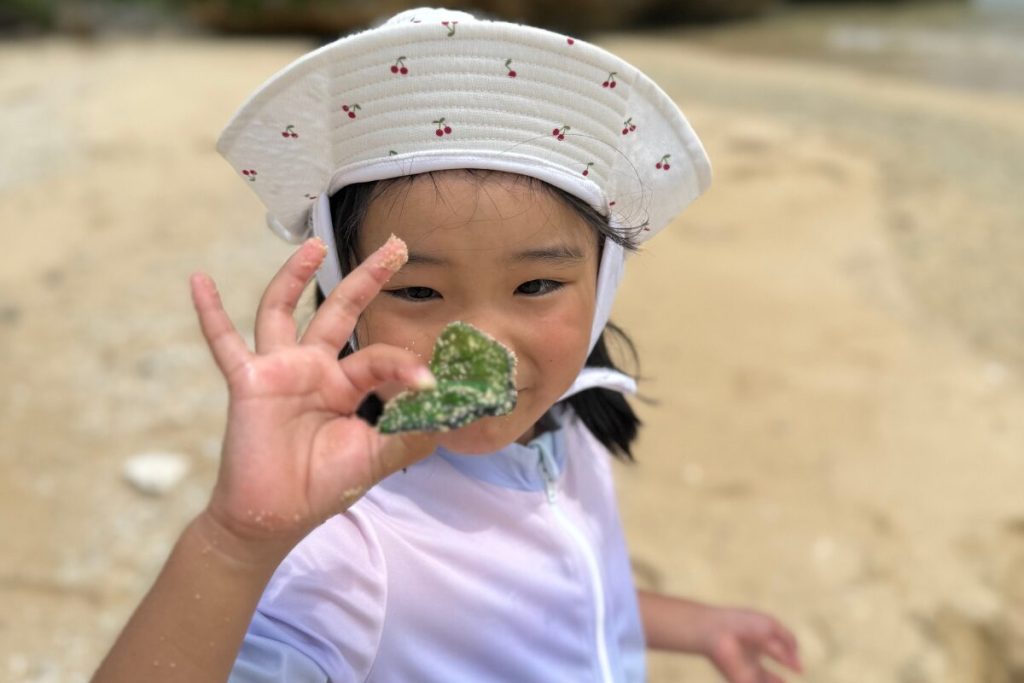 珍しいシーグラスをカメラに向かって自慢