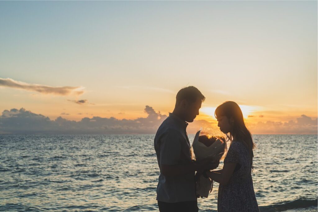美しい夕日を背景に花束を持っている二人