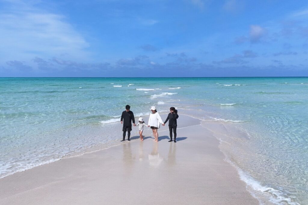 ユニの浜の浅いところを皆で手を繋いで歩く姿
