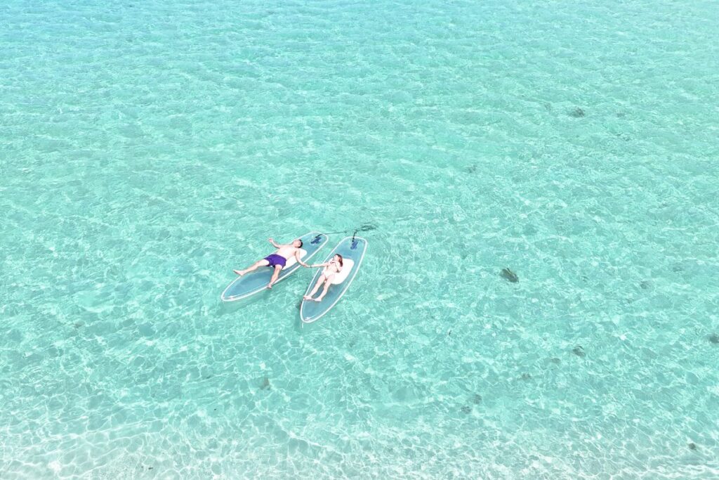高透明度の海の真ん中にお二人のサップのみの写真
