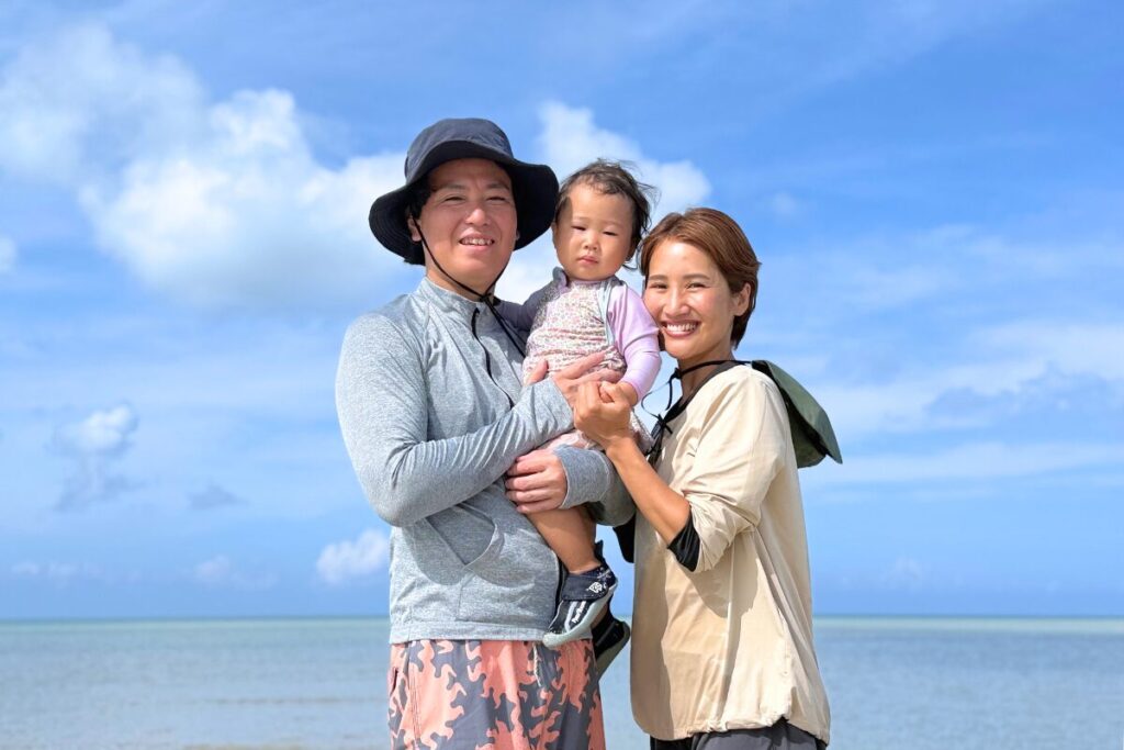 きれいな海をバックに家族3人での記念撮影