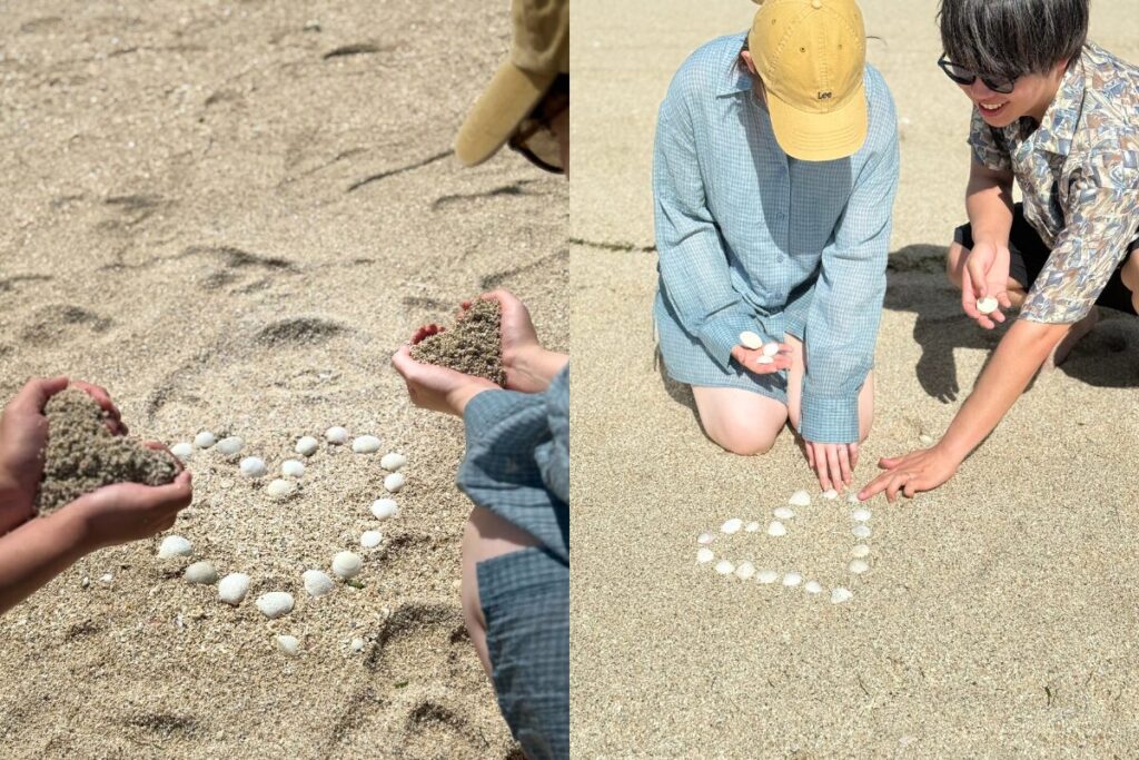 ハートの形に貝殻を並べるふたり