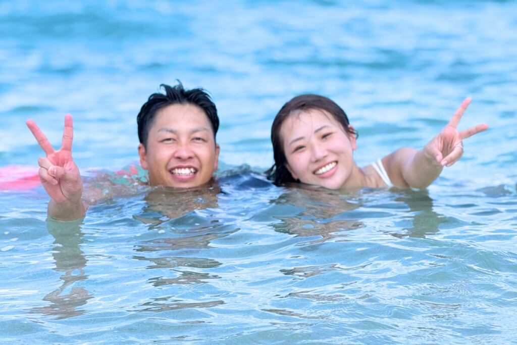 海に入りながらニッコニコでピースしているふたり