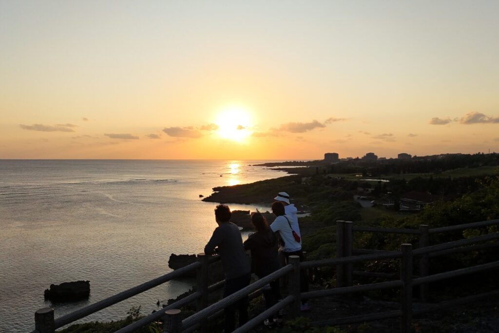 山頂で皆並んで夕日を見る様子