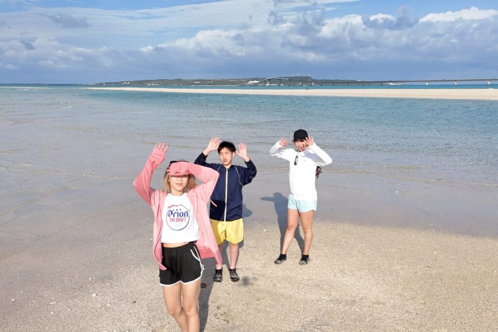 きれいに晴れたユニの浜 眩しい様子でドローンに笑顔を向けてくれてる