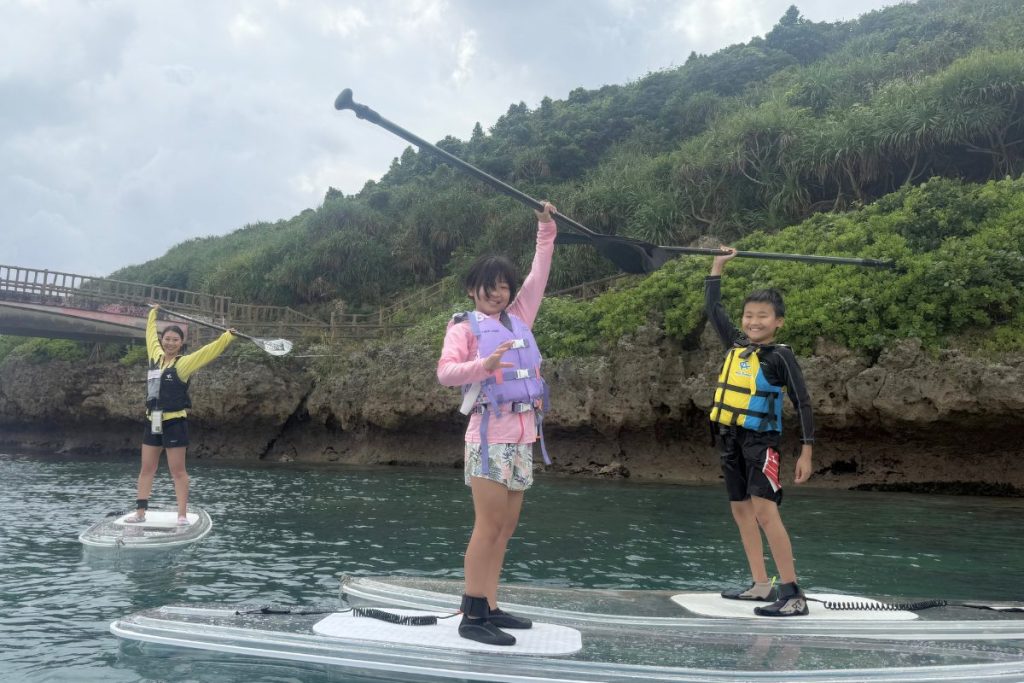 サップに乗ってリアクションをとる子供たち