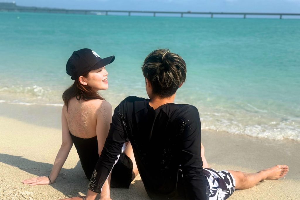 砂浜に座り、お喋りをするふたり