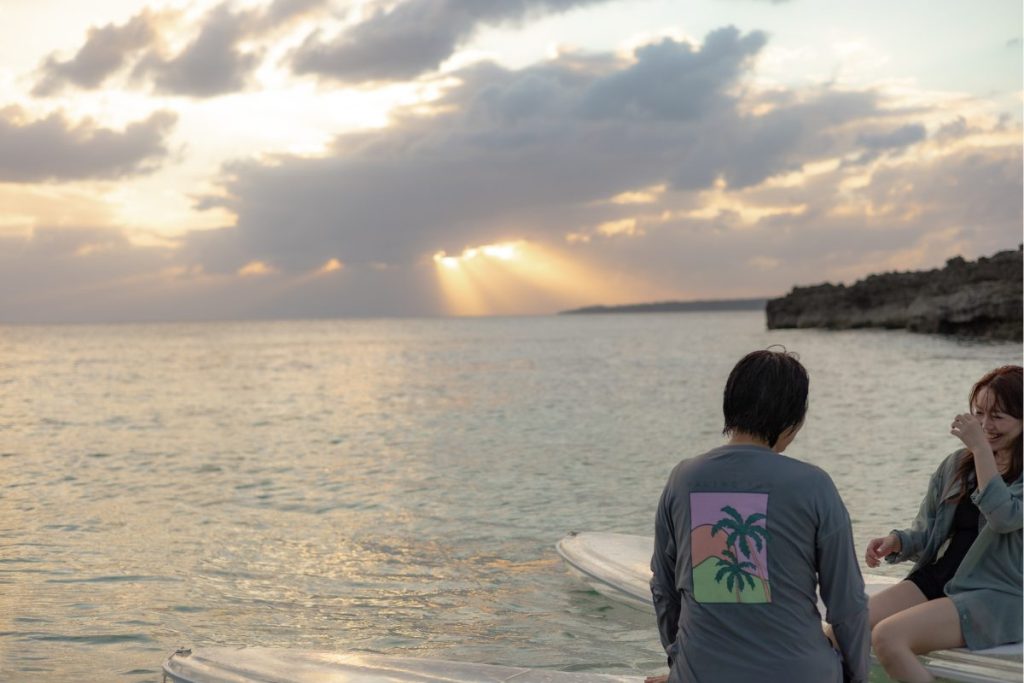 宮古島のサンセットSUPツアーで、雲間から差し込む夕陽を背景に笑い合うまあいさん・なつみさん親子