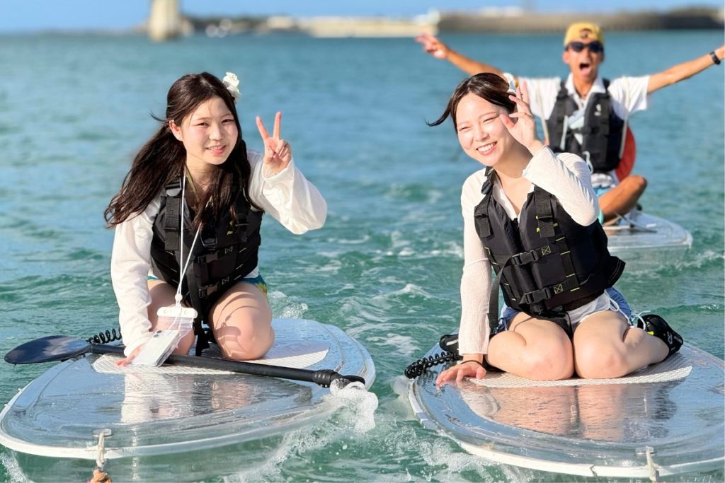 宮古島のクリアSUPツアーで笑顔のれなちゃんとここあちゃん！後ろではガイドもポーズを決める楽しい記念写真